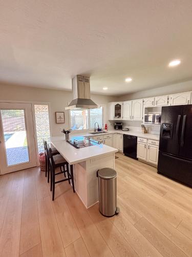 a kitchen with white cabinets and a black refrigerator at Hermosa Hideaway in Tempe