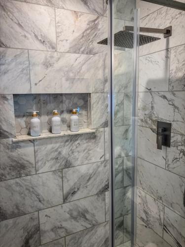 a bathroom with a shower with white marble walls at Hermosa Hideaway in Tempe