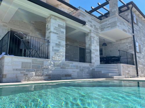 a house with a swimming pool in front of a house at Villa Andolini in Momjan