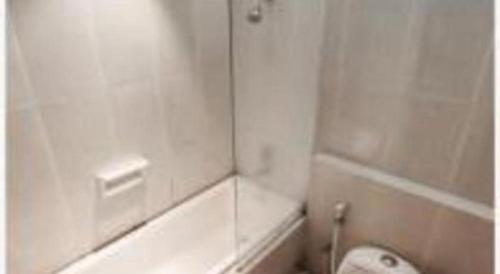 a white bathroom with a toilet and a shower at The Oxalis Regency Hotel in Magelang