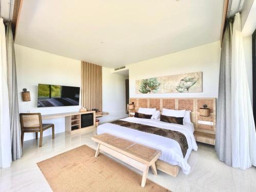 a bedroom with a large bed and a tv at Truntum Boutique Mandalika in Kuta Lombok