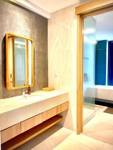 a bathroom with a sink and a mirror and a shower at Truntum Boutique Mandalika in Kuta Lombok