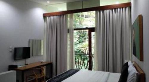 a bedroom with a bed and a window and a television at VillaTel Salse in Bandung