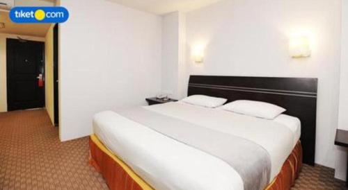 a bedroom with a large bed in a hotel room at Kenari Tower Hotel in Makassar