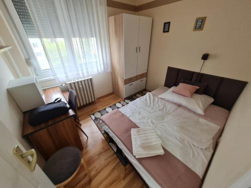 a small bedroom with a bed and a window at Etele Apartman in Budapest