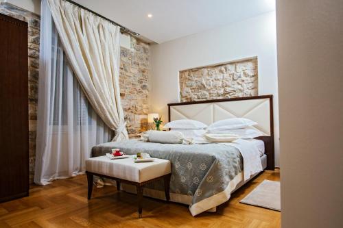 a bedroom with a king sized bed and a table at Heritage Hotel Antique Split in Split