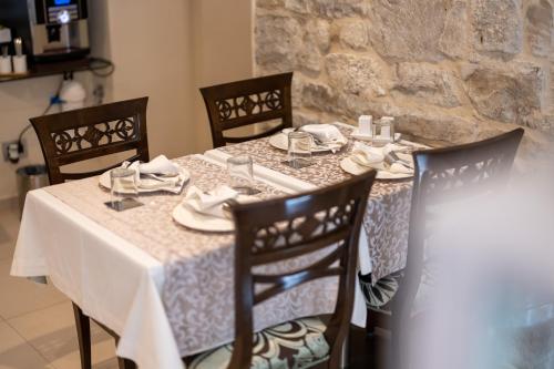 a dining table with a white tablecloth and chairs at Heritage Hotel Antique Split in Split