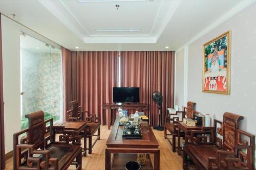 a room with wooden tables and chairs and a television at Hung Long Hotel in Bắc Ninh