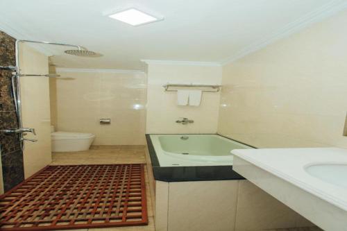 a bathroom with a tub and a toilet and a sink at Hung Long Hotel in Bắc Ninh