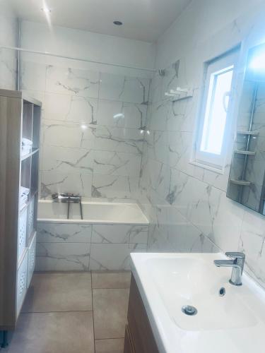 une salle de bain blanche avec un lavabo et une baignoire dans l'établissement Appartement 3 pièces sur Mougins, à Mougins