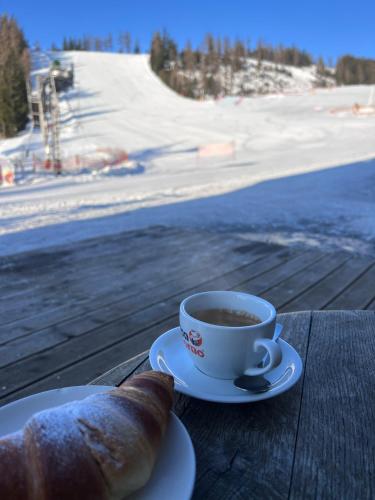 a cup of coffee and a piece of bread on a table at Penzion UNA in Liptovský Ján