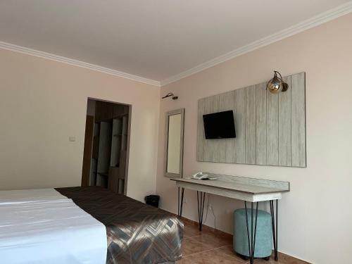 a bedroom with a bed and a desk and a tv at Oleander House and Tennis Club in Sunny Beach