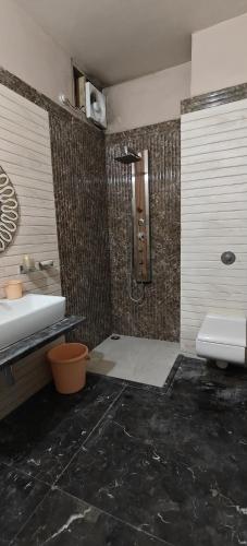 a bathroom with a shower and a sink and a toilet at Banarasi Courtyard in Varanasi