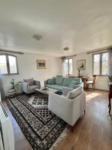 a living room with a blue couch and a rug at RÉNOVÉ, vue SUR Palais des Papes, terrasse et WIFI TROISIEME ETAGE in Avignon