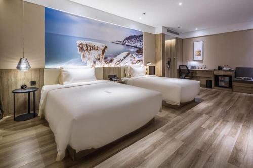 a hotel room with two beds and a desk at Atour Hotel Weihai Shidao in Dongshan