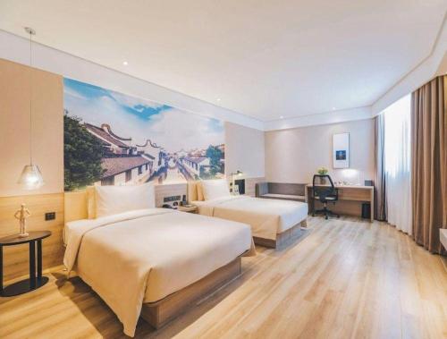 a hotel room with two beds and a painting on the wall at Atour Hotel Weihai Shidao in Dongshan