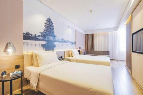 a hotel room with two beds and a tv at Atour Hotel Weihai Shidao in Dongshan