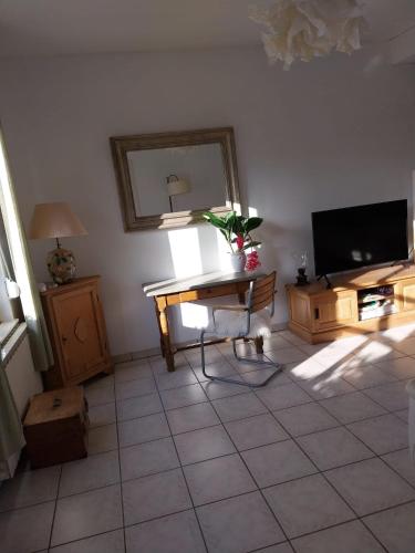 a living room with a table and a television at Maison de charme dans la Somme in Miraumont