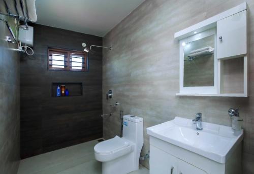 ein Badezimmer mit einer weißen Toilette und einem Waschbecken in der Unterkunft Matts Homestay Alleppey in Jāmb