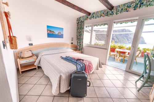 a bedroom with a bed with a suitcase in it at Appartamenti Casa del Sole in Ischia