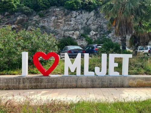 a red heart is in front of a sign at Studio apartment Dragana in Sobra