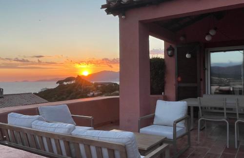 d'un balcon avec des chaises et une vue sur le coucher du soleil. dans l'établissement Maison de Lou, à Porticcio