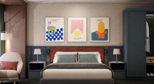 a bedroom with a bed and some pictures on the wall at Lenid Hotel Tho Nhuom in Hanoi