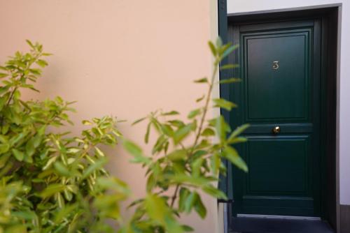 a green door next to a building with plants at Locanda Ca Da Iride in Riomaggiore