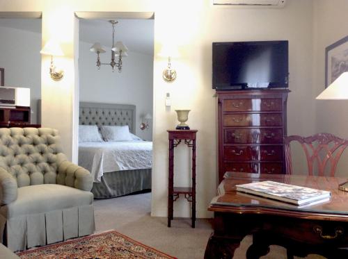 - une chambre avec un lit et une commode avec une télévision dans l'établissement Casa Corp Boutique Suites in Condesa, à Mexico