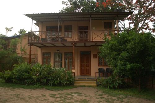 a house with a balcony on top of it at Tamarind Tree Masinagudi in Masinagudi