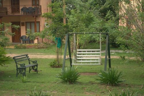 a park with a bench and a swing at Tamarind Tree Masinagudi in Masinagudi