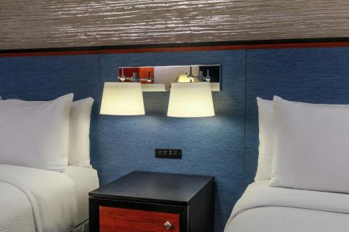 a hotel room with two beds and a table with two lamps at Fairfield By Marriott New York Manhattan Times Square in New York