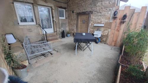a black table and chairs in a courtyard at Gîte La Giroflee in Meillonnas