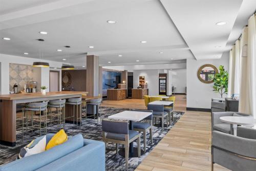 a lobby of a hotel with tables and chairs at La Quinta Inn & Suites by Wyndham Santa Cruz in Santa Cruz