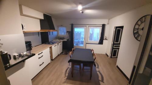 a kitchen with a table and a dining room at Gîte La Giroflee in Meillonnas