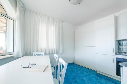 a kitchen with a white table and two chairs at Appartamenti Casa del Sole in Ischia