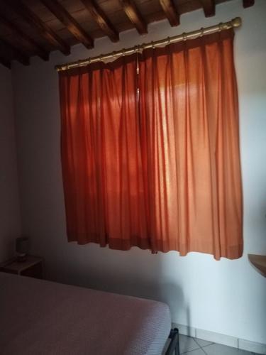 a bedroom with a bed and an orange curtain at Il Casale di Luna in Saturnia