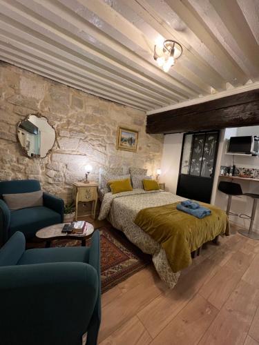 une chambre avec un lit et un mur en pierre dans l'établissement Élégant studio Cœur du Centre ville avec WIFI, à Avignon