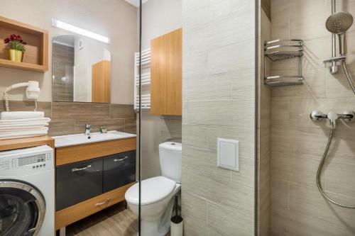 a bathroom with a toilet and a sink and a washing machine at Quebec Flat in Oradea