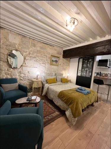 une chambre avec un lit et un mur en pierre dans l'établissement Élégant studio Cœur du Centre ville avec WIFI, à Avignon