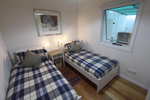 a small room with two beds and a window at Spot the Sea eagle in Woodbridge