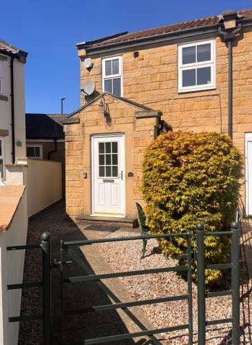 a brick house with a white door at Castle Cottage in Harrogate