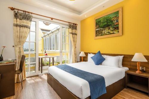 a hotel room with a bed and a window at TRIPLE Riverside Villa Hotel HoiAn in Hoi An