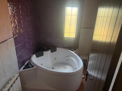a white tub in a bathroom with a window at Hotel Rural Los Abriles in El Toro