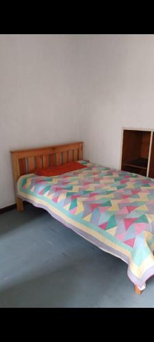 ナイロビにあるDam estate 20のベッドルームにカラフルな掛け布団付きのベッド1台