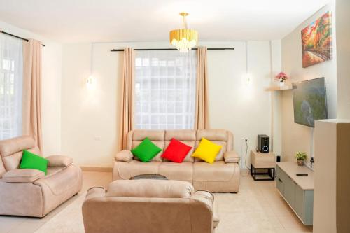 a living room with two chairs and a couch with colorful pillows at Shalom Haven in Naivasha