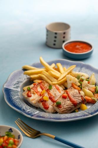 a plate of meat and french fries and ketchup at Pondicherry Executive Inn in Puducherry