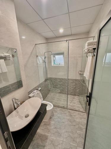 a bathroom with a shower and a toilet and a sink at 1 House in Da Lat