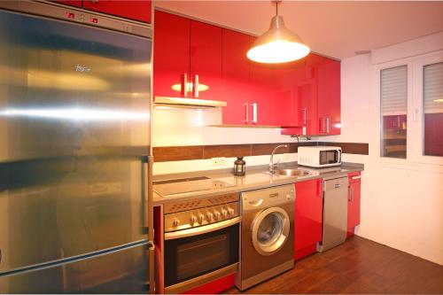 アビラにあるÁvila Flats Soterrañaのキッチン(赤いキャビネット、洗濯機付)