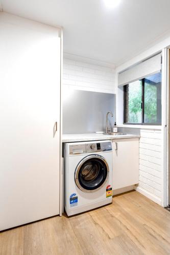 a washer and dryer in a white kitchen at The River Nook on Hurst in Ocean Grove